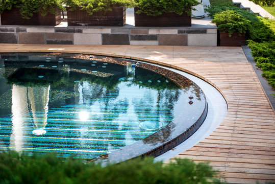 Modern round swimming pool design with clear water locating at residence outdoor