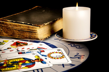 tarot tarots cards with magic book and candle on astrology wheel like esoteric concept 