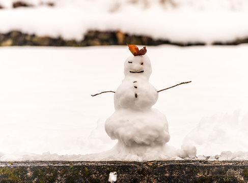 Hand made snowman, built with leaf and branch, at outdoor snow field in early winter season in Japan