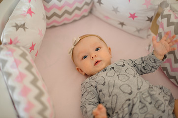 Little cute girl in the dress lying in her cozy bed
