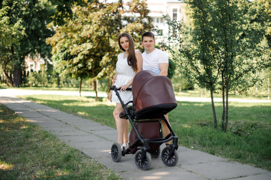 Parents and their little daughter in the babby carriage