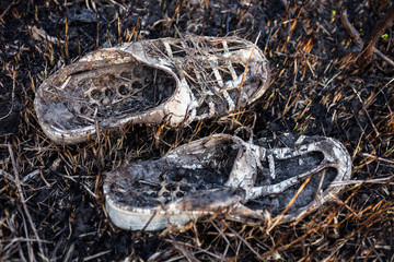 Old burnt shoes on the burnt grass