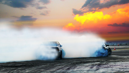 Blur of two drifting cars battle on speed track at sunset. Motorsport concept. - obrazy, fototapety, plakaty