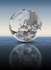 Poland on translucent globe above water