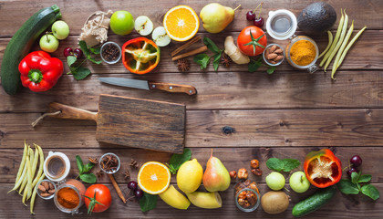 Healthy food, clean food selection:  fruits, vegetables, seeds, spices on brown boards with free space in the middle.