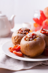  baked apples with cinnamon, walnuts and honey on a white background. Autumn or winter dessert