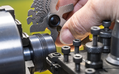 Close-up of measurement by thread pitch gauge. Detail of a machinist's hand with the set of...