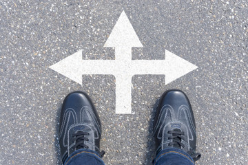 Fototapeta premium man standing on road with three direction arrow choices, left, right or move forward