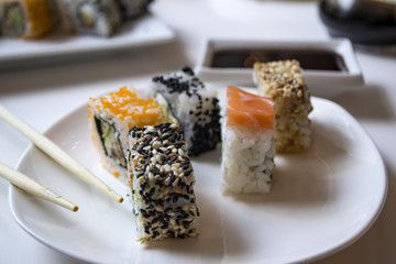Set of sushi rolls on a white plate.