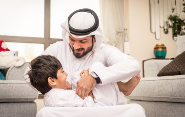 Arabian boy and father playing together at home