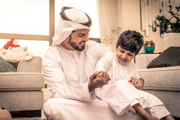 Arabian boy and father playing together at home