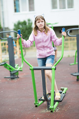 teenage girl is engaged in children's exercise equipment