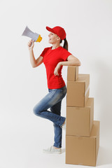 Full length of delivery fun woman in red cap, t-shirt isolated on white background. Female courier screaming in megaphone hot news, standing near empty cardboard boxes. Receiving package. Copy space.