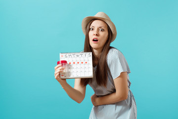 Portrait of sad woman in dress holding white bottle with pills, female periods calendar, checking...