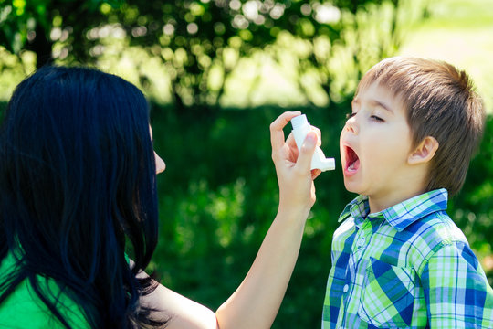 Mother Holding A Inhaler For Cute Little Kid Boy Son In Summer Park