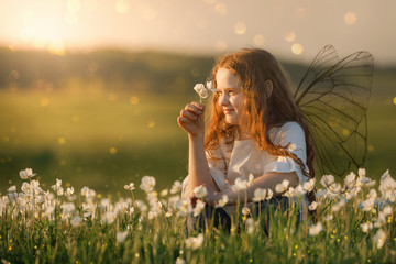 Cute curly baby dreaming on meadow outdoors.