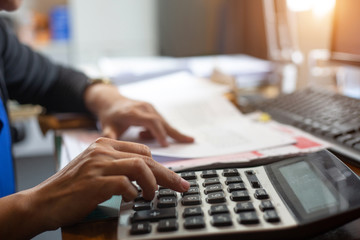 A businesswoman  using calculator investment charts at his workplace. Business concept.