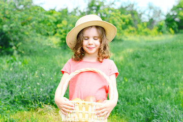 child holds a basket with red apples inside.	