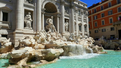 Fototapeta na wymiar Der berühmte Trevi-Brunnen in Rom verziert mit Säulen und Figuren und herrlich blauem Wasser.
