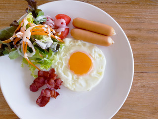 A closeup of eggs, bacon, ham, and sausage on top of toast