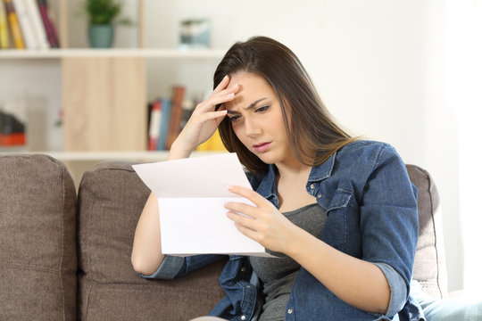 Concerned woman reading bad news in a letter