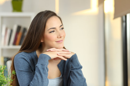 Confident pensive woman looking at side at home