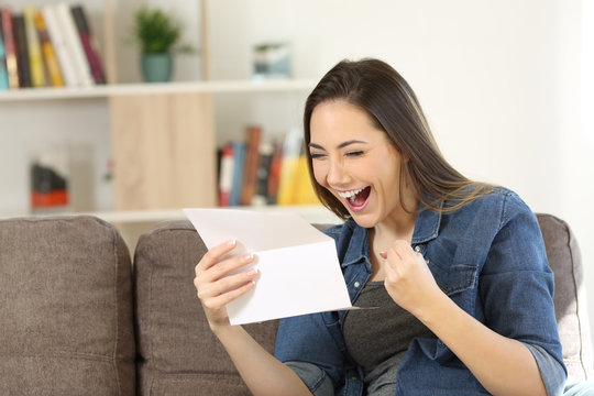 Excited woman reading great news in a letter