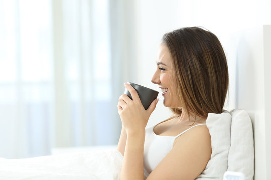 Girl drinking coffee at breakfast in the morning on the bed