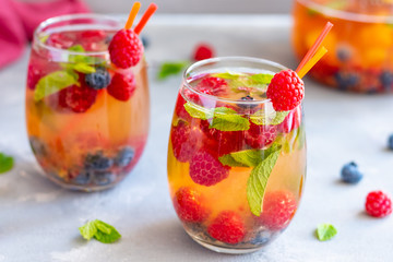 Summer white refreshing wine sangria with berries and mint.