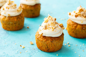 Sweet carrot and walnut cupcakes on the blue background