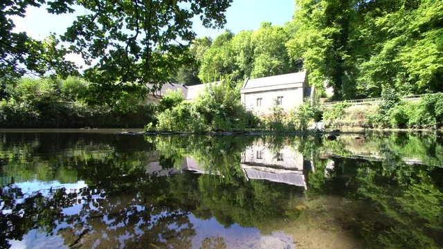 Old stone house with beautiful reflection around Swanbourne Lake, Arundle, United Kingdom