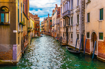 Fototapeta na wymiar View of Venetian Canal with Gondola in Venice, Italy
