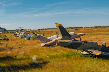 Abandoned broken old military fighter airplanes on grassy ground