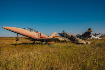 Abandoned broken old military fighter airplanes on grassy ground