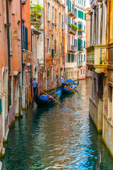 Obraz na płótnie Canvas Gondoliers Calmly Propelling Along Canal in Venice, Italy