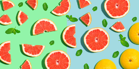 Halved fresh grapefruits on bright color background