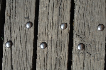 Wooden boards of a bridge with rivets.