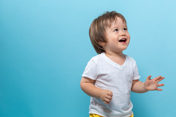 Toddler boy smiling on a bright blue background