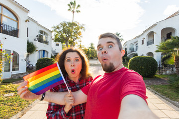 Young man and woman surprised when the first time came gay parade