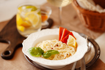 Lunch meal pasta with cream sauce, served with glass of white wine