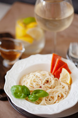 Lunch meal pasta withsmoked salmon and parmesan, served with glass of white wine