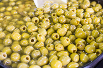 A lot of fresh green olives in a bowl