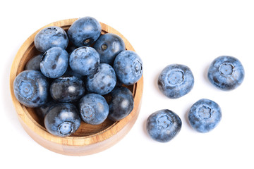 fresh ripe blueberry in wooden bowl isolated on white background. Top view. Flat lay pattern