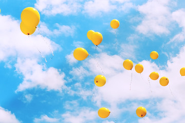 Balloons in the blue sky flying away. Toned, soft focused.