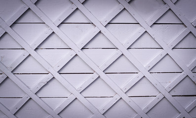 gray wooden fence with square lattice. vignette, background, texture.