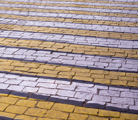 zebra pedestrian road marking on brick pavement. background, perspective.