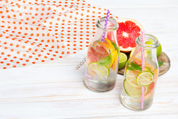 Infused flavored water with fresh fruits on white wooden background.Refreshing summer homemade  detox water