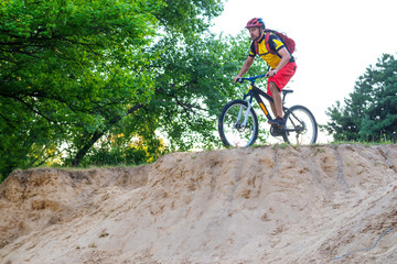 Fototapeta na wymiar Сoncept of an active lifestyle, a cyclist riding a mountain bike, a bright summer photo.