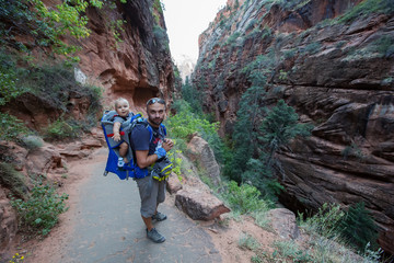 A man with his baby boy are trekking in Zion national park, Utah, USA