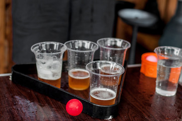 Beer pong game outdoors. Fresh kraft beer in glasses. Top view